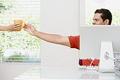 Man at Computer Reaching for a Cup of Coffee