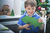 Smiling boy making Christmas ornament at home