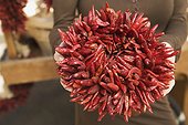 Woman Holding Wreath of Chili Peppers