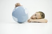 Girl holding globe, head resting on arms, looking at camera