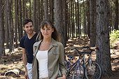 Smiling young couple standing in pine forest