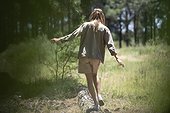 Young woman walking on log in forest