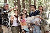 Family reading a map while standing in forest