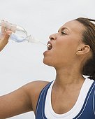 African woman drinking from water bottle