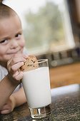 Hispanic boy dunking cookie in milk