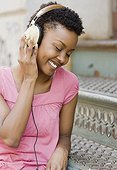 African woman listening to headphones outdoors