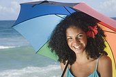 African woman at beach with umbrella