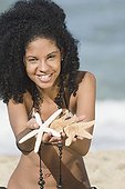 African woman holding out starfish