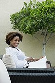 African woman reading on patio