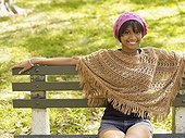 Hispanic woman wearing cap and shawl in park