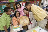 African teacher and students looking at globe