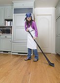 Woman sweeping kitchen floor
