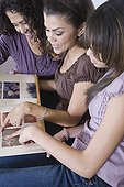 Multi-generational women looking at photo album