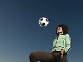 African woman kneeing soccer ball