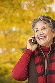 African woman using cell phone outdoors in autumn