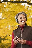 African woman wearing headphones holding mp3 player