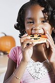 African girl eating Halloween cookie