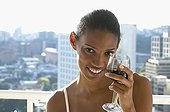African woman drinking wine on balcony