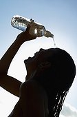 Silhouette of woman pouring water over head