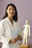 Asian female doctor next to Acupuncture model