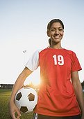 Mixed race woman posing with soccer ball