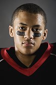 Mixed race football player with face paint under eyes