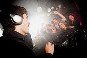 DJ playing music for crowd in nightclub