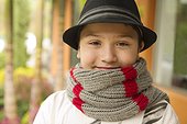 Smiling Hispanic boy in hat and scarf