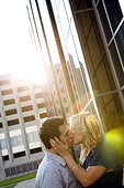 Caucasian couple kissing near building
