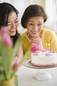 Japanese mother and daughter looking at birthday cake