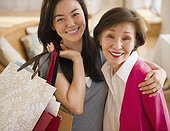Japanese daughter holding shopping bags and hugging mother