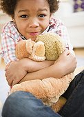 Black boy hugging teddy bear