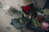 Woman cooking egg on grille