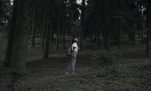 Black woman standing in forest looking up