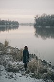 Caucasian woman standing near river in winter