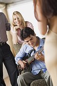 Friends at party, man playing guitar
