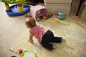 Baby girl, crawling towards toys, rear view, elevated view