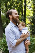 Father holding baby son, outdoors