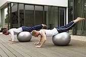 Men Exercising with Exercise Balls on Terrace