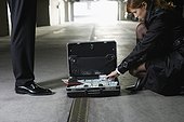 Woman Looking Through Briefcase of Cash and Documents