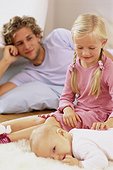 Father, daugther and baby on floor in living room