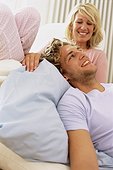 Couple, man lying in cushion, woman looking at man