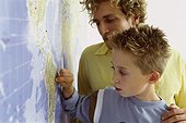Father and son looking at world map