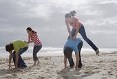 Young People Playing Leapfrog on Beach