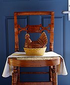 Statuette of a rooster kept on the chair near the door