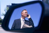 Businessman talking to someone on the phone (wing mirror)
