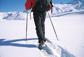 Person crossing snow-covered landscape in snowshoes