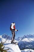 Woman standing on mountain top with ski sticks