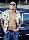 Young man leaning against car