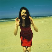 Woman in a red dress on the beach